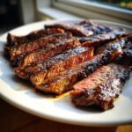 Close-up of perfectly grilled and sliced steak, glistening with marinade, ready to eat after using the Carne asada marinade.