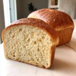 Close-up of the soft, open crumb structure of a freshly baked sourdough sandwich bread loaf.