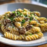 Close-up of creamy beef pasta made with fusilli noodles, rich sauce, and fresh parsley garnish.