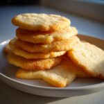 A stack of golden brown, soft sugar cookie treats sprinkled generously with sparkling sugar.